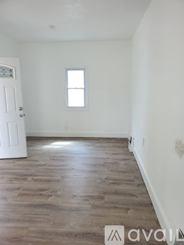 A room with wooden flooring and a white door.