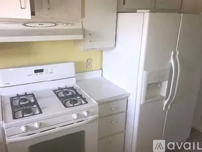 A white stove and refrigerator in a kitchen.