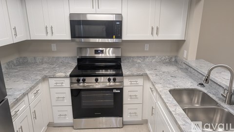 A modern kitchen with a stove top oven and microwave.