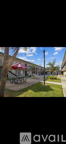 A park with a picnic table and a building in the background.