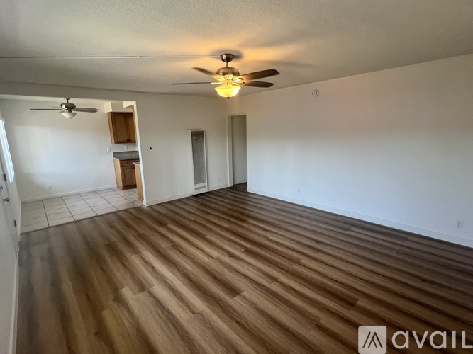 A room with wooden flooring and a ceiling fan.