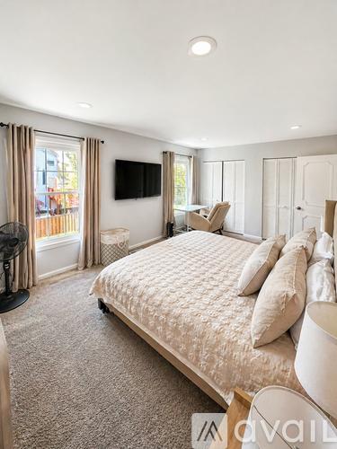A bedroom with a large bed and a flat screen TV mounted on the wall.