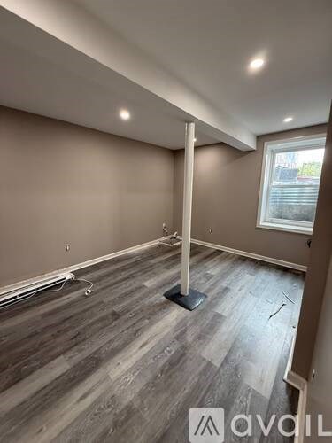 A room with wooden flooring and a window.