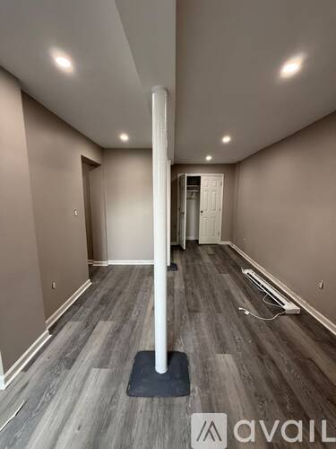 A room with a long white pole in the middle of the floor.