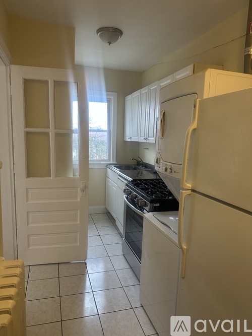 A kitchen with a white fridge and a white door.