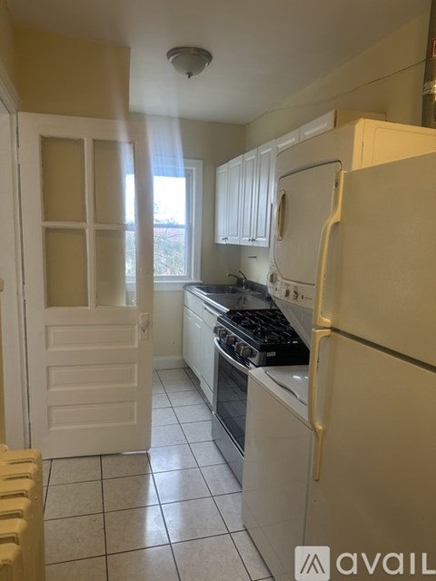 A kitchen with a white fridge and a white door.