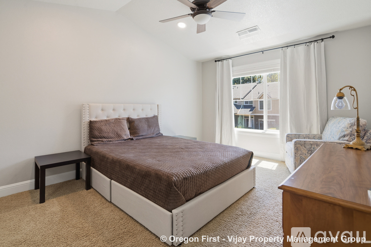 A bedroom with a large bed and a ceiling fan.