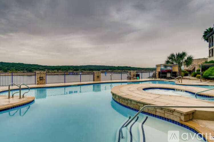A large outdoor swimming pool with a hot tub and a view of the countryside.
