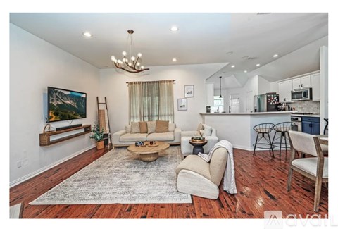 A living room with a wooden floor and a large painting on the wall.