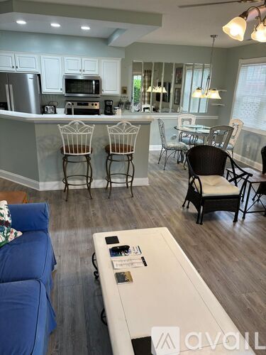 A living room with a white coffee table and blue couch.