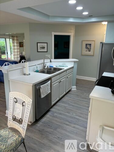 A kitchen with a sink and a chair.