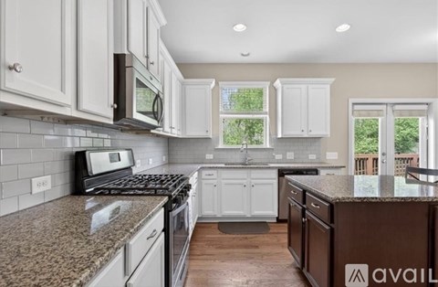 A kitchen with granite countertops and white cabinets.