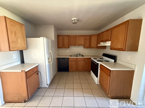 A kitchen with wooden cabinets and white appliances.