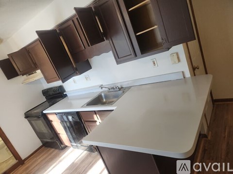 A kitchen with a white countertop and brown cabinets.