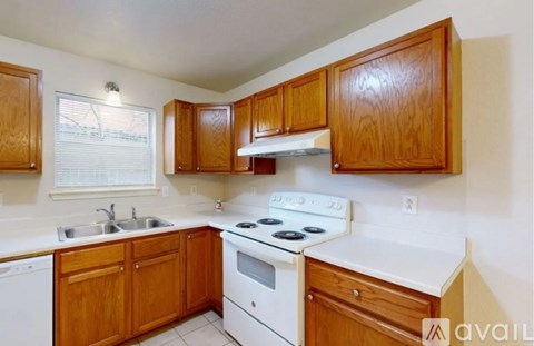 A kitchen with wooden cabinets and white appliances.