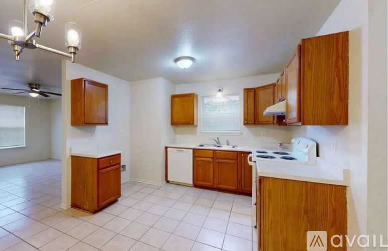 A kitchen with wooden cabinets and a white dishwasher.