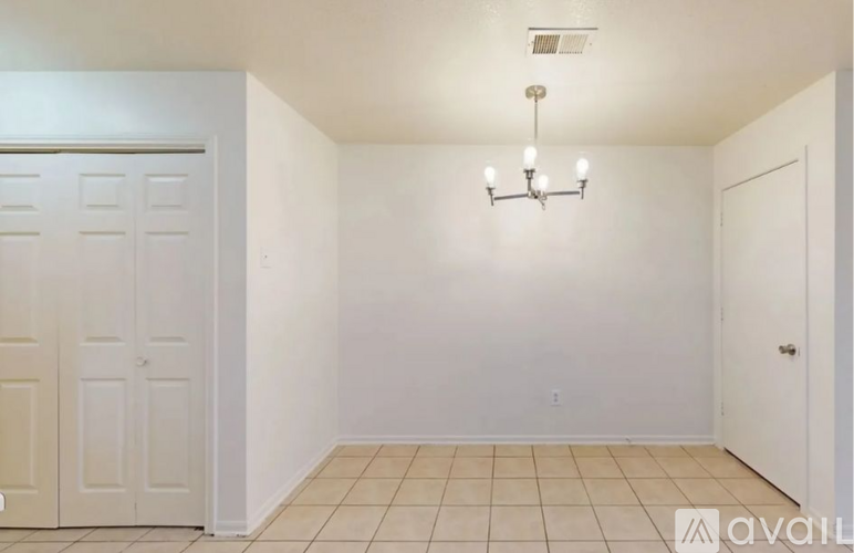 A room with a chandelier and a tiled floor.