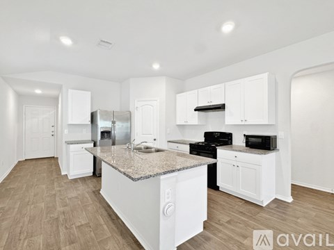 A kitchen with white cabinets and a granite countertop.