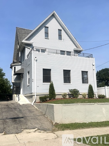 A two-story house with a white exterior and a grey roof.