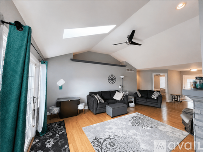 A living room with a grey couch and a black and white rug.