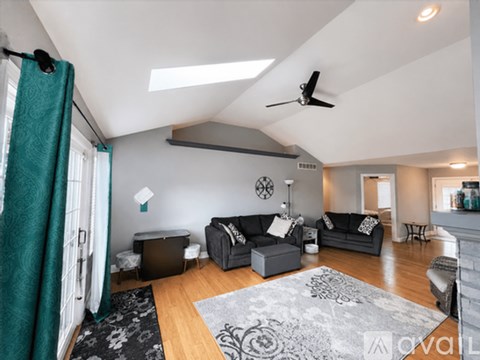 A living room with a grey couch and a black and white rug.