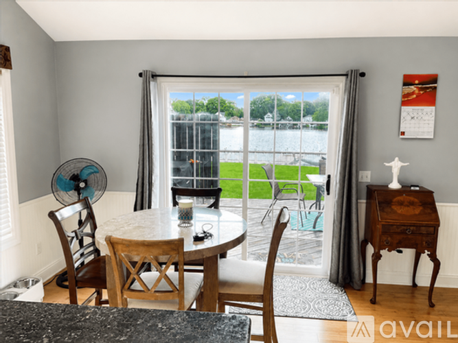 A dining room with a table and chairs and a fan.