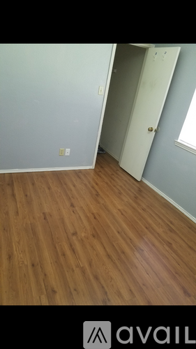 A room with wooden flooring and a white door.