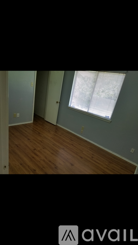 A room with a window and wooden flooring.