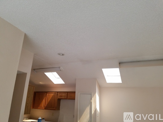 A kitchen area with a refrigerator and cabinets.