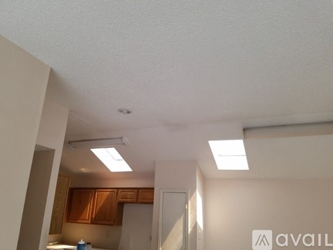 A kitchen area with a refrigerator and cabinets.
