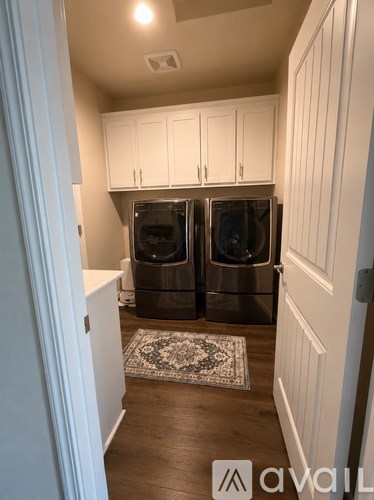 A kitchen with white cabinets and a rug on the floor.