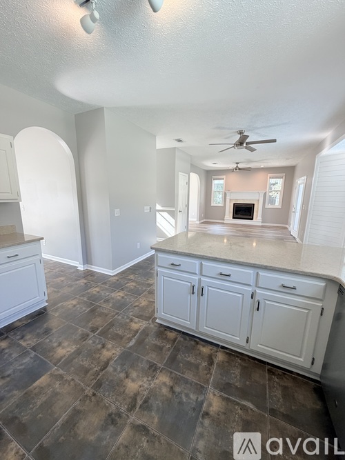 A kitchen with white cabinets and a tiled floor.