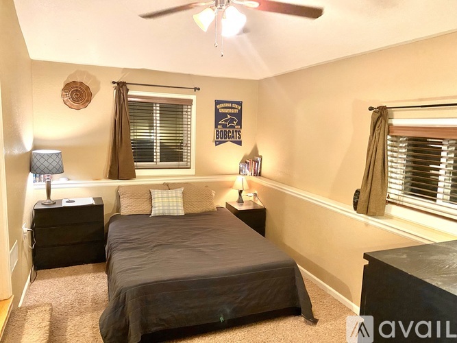 A bedroom with a bed, dresser, and ceiling fan.
