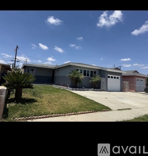 A house with a grey roof and a white garage door.