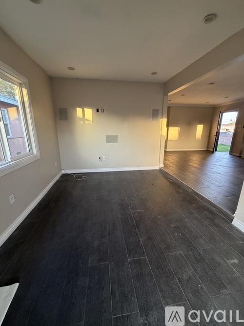 A room with black wooden flooring and white walls.