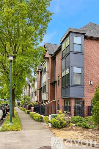 A street view of a residential area with apartment buildings and a sidewalk.