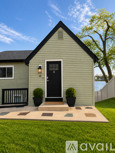 A house with a black door and a small front yard.