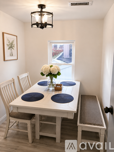 A dining room with a white table and chairs.