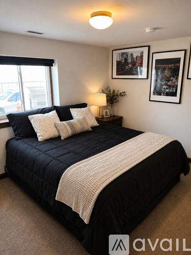 A bedroom with a large bed and two pictures on the wall.