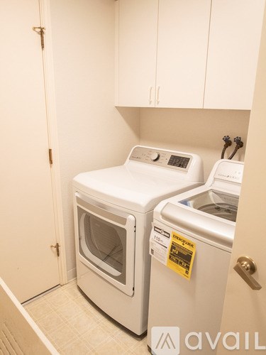 A white dishwasher and oven are in a small kitchen.