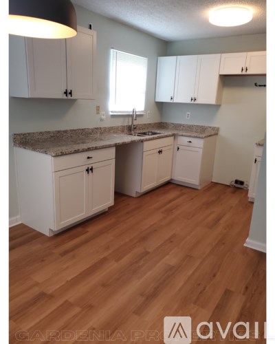 A kitchen with white cabinets and a granite countertop.