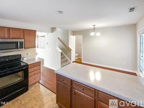 A kitchen with brown cabinets and a black oven.