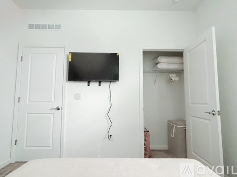 A bedroom with a bed, a television, and a closet.