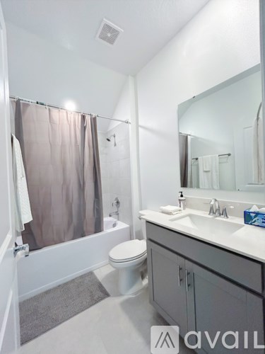 A bathroom with a toilet, sink, and shower.