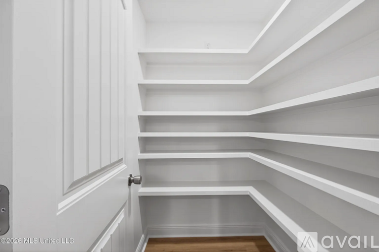 A white interior with a door on the left and shelves on the right.