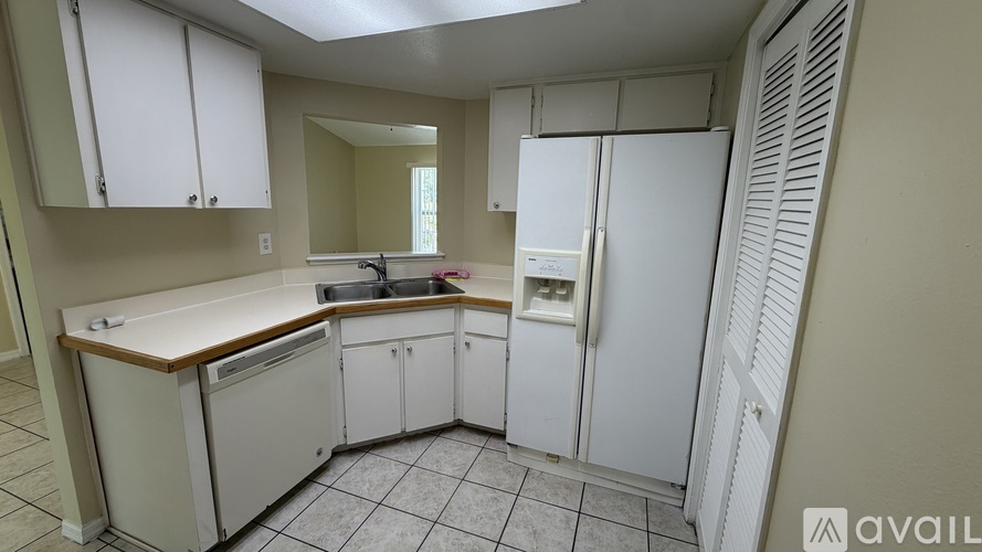 A kitchen with white cabinets and a white refrigerator.