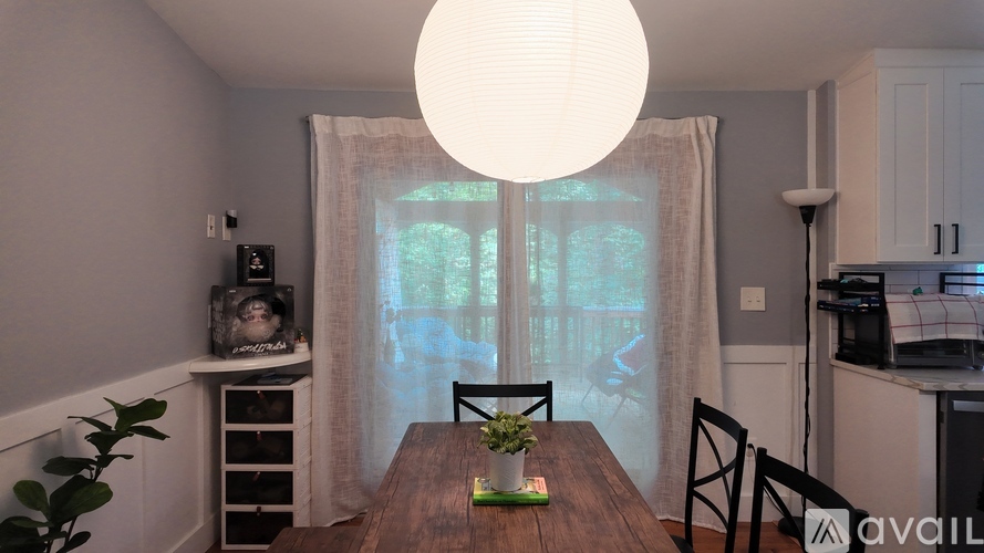 A dining room with a wooden table and chairs.