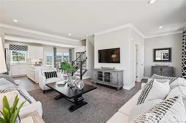 A living room with a black coffee table and white furniture.