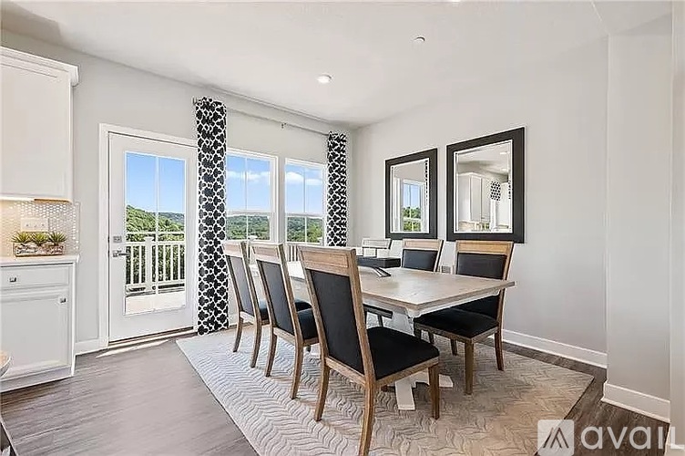 A dining room with a table and chairs.