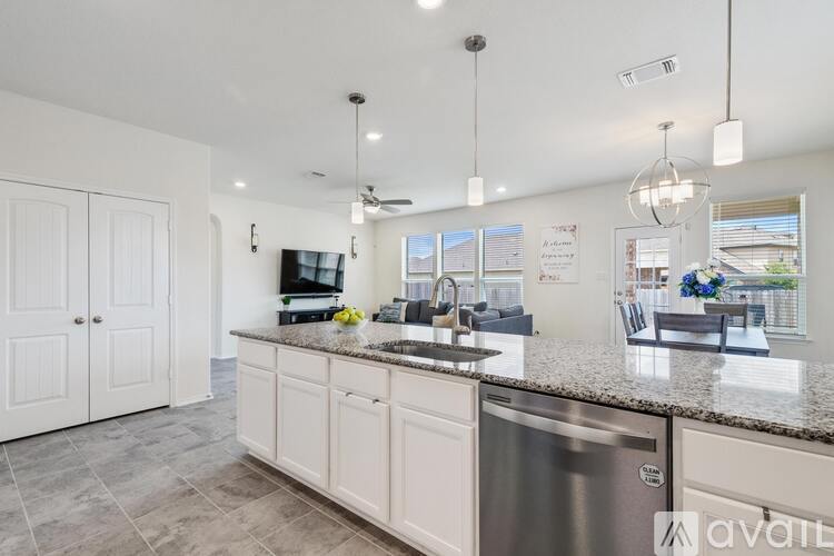 A kitchen with a stainless steel dishwasher and granite countertops.
